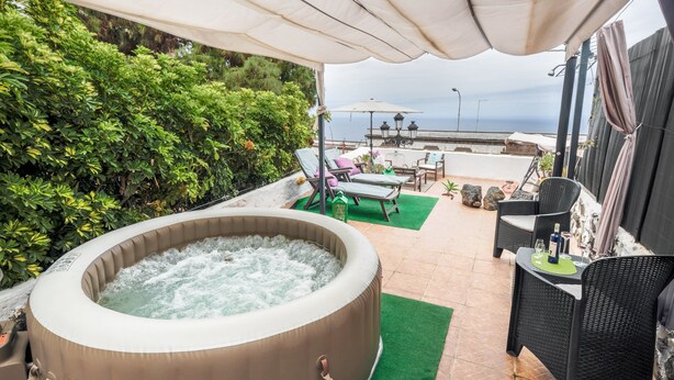 A hot tub with a view of the sea, outdoor seating, and greenery. - Holiday Apartment "Casa Amparo" with Terrace, Ocean View, Whirlpool & Wi-Fi (Icod de los Vinos)