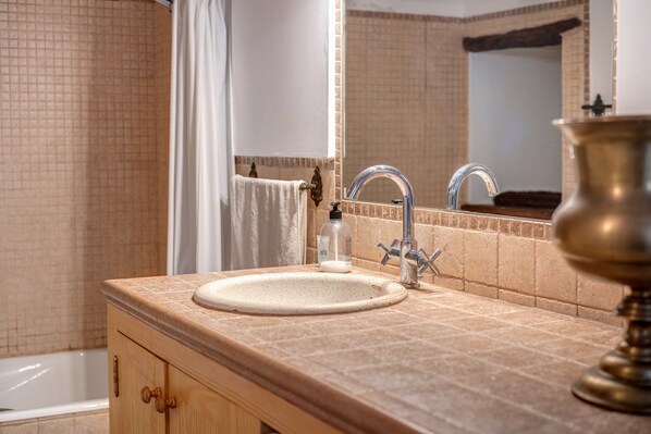 A bathroom with a sink, mirror, and bathtub. - Peaceful "Antonia" House with Mountain Views, Terrace, Wi-Fi (soller)