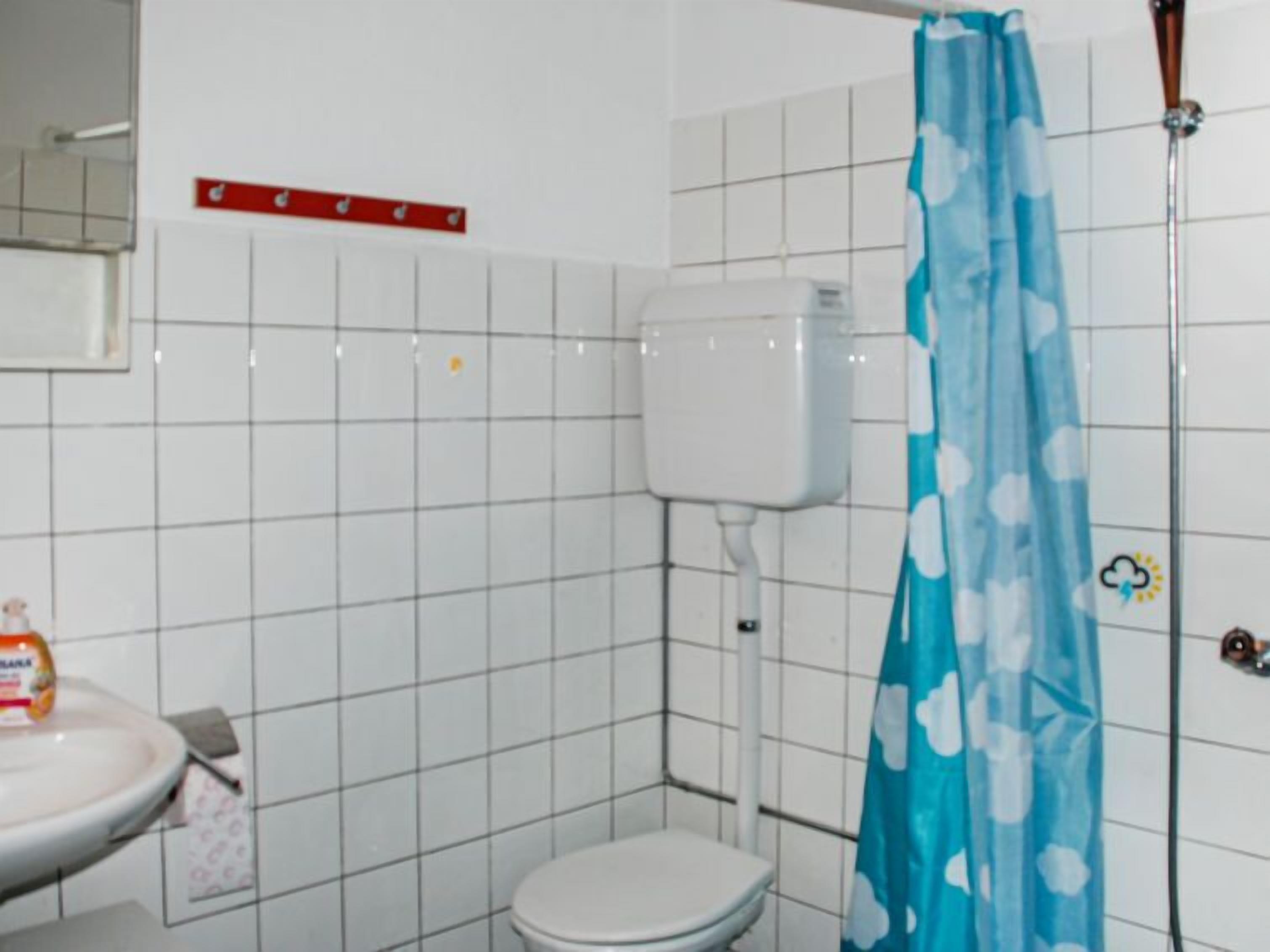 A small bathroom with a toilet, a sink, and a shower curtain.