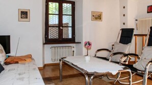 Ein Zimmer mit einem Bett, einem Tisch, zwei Stühlen, einer Heizung und einem Fenster.