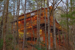 A cabin surrounded by trees with multiple levels and balconies.