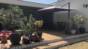 Un'area patio con piante in vaso, una macchinina giocattolo e un tavolo con sedie.