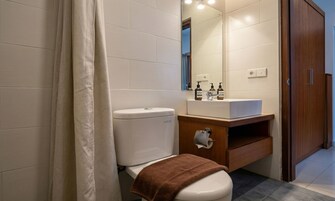 Une salle de bain moderne équipée de toilettes, d’un lavabo et d’un miroir.