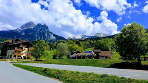 Vistes a la muntanya amb carretera, edificis i un rètol que diu 'Hotel Alpenblick'.