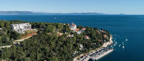 A coastal town with a marina, residential buildings, and a clear view of the sea.
