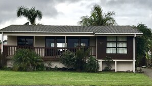 Een huis met twee verdiepingen, een balkon, een veranda en een nummer 77.