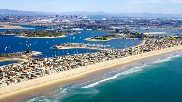 Eine Küstenstadt mit Strand, Marina und städtischem Gebiet.