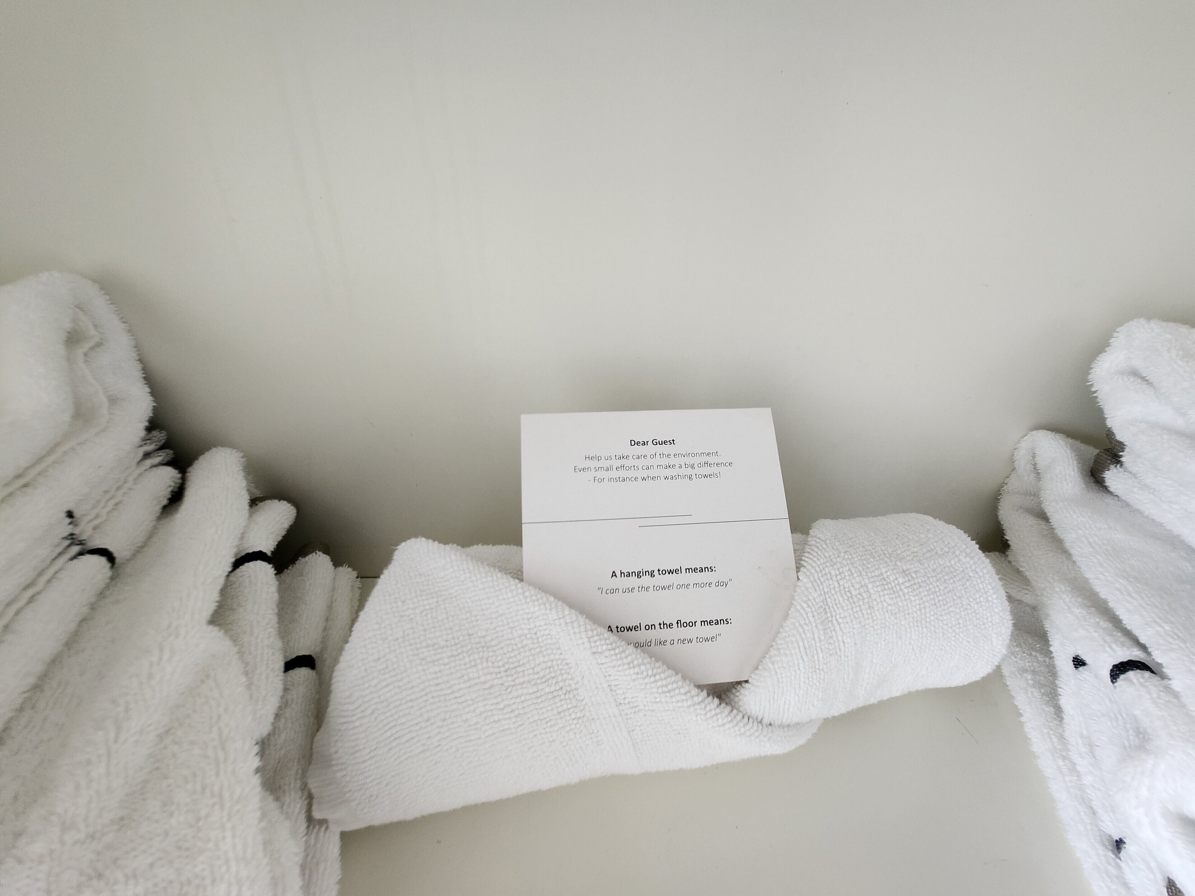 A white towel with a message card about towel usage.