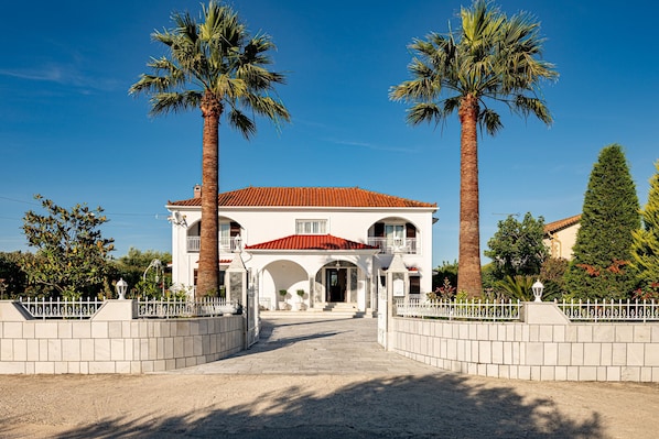 Stunning two-story building with a grand entrance, arched doorways, and a balcony.