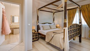 A four-poster bed with a canopy, a bedside table with a lamp, and a mirror on the wall. - Aigli Villa (Zakynthos)