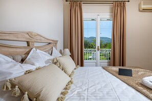 Relax in this stylish room with a large bed, balcony, and glass door leading to a scenic view.