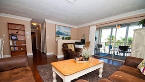 A living room with a fireplace, a coffee table, and a bookshelf.
