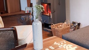 Ein gemütliches Wohnzimmer mit einem Holztisch, einer Blumenvase und einem Kamin.