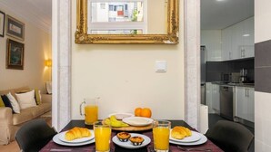 Ein Frühstückstisch mit Croissants, Orangensaft und Muffins in einem modernen Zimmer mit großem Spiegel und Blick ins Freie.