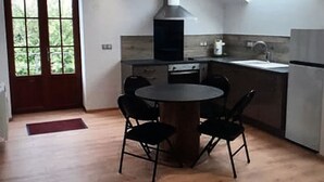 Une cuisine moderne dotée d’un îlot central, d’une verrière et offrant une vue par la fenêtre.