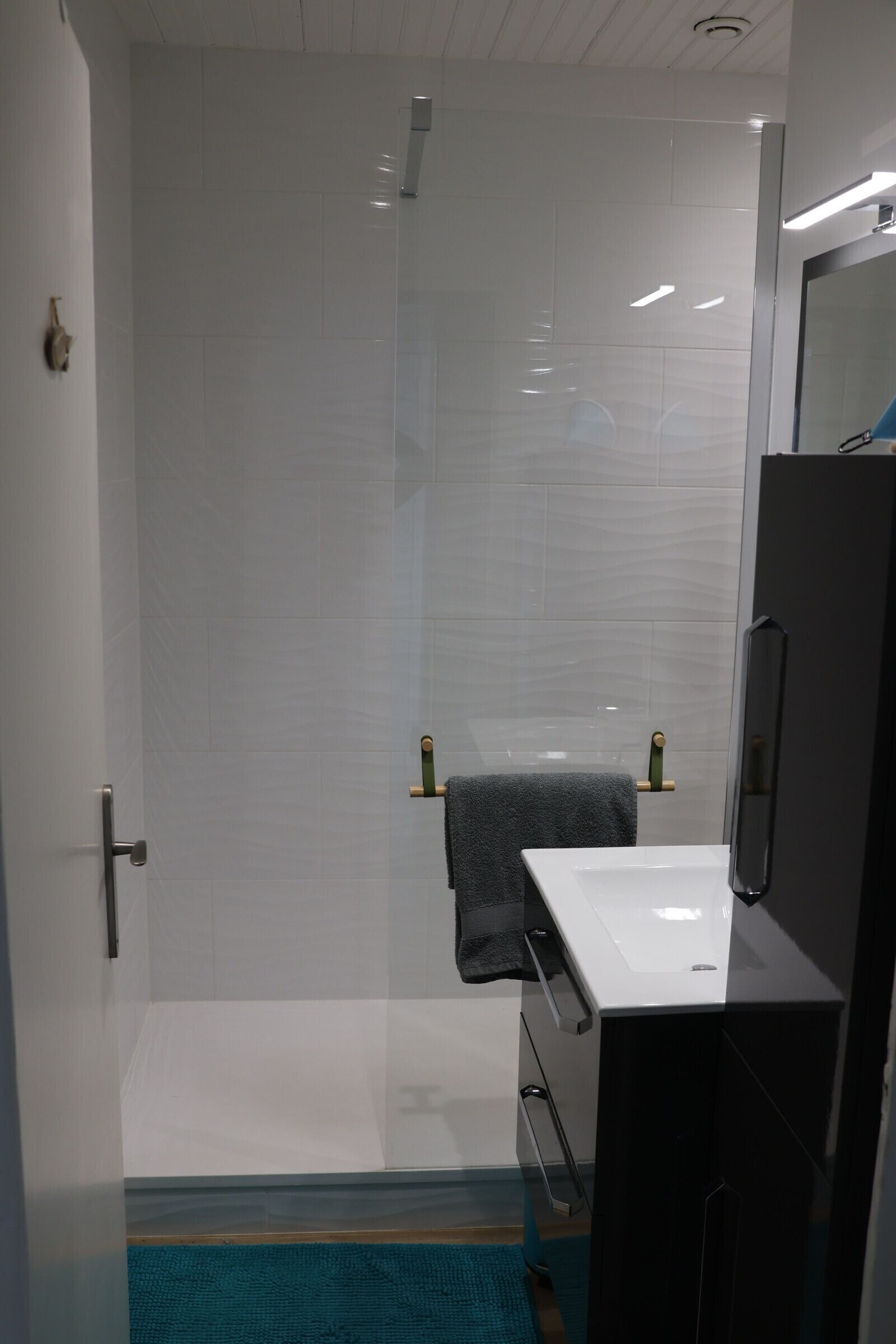 A bathroom with a shower, a sink, and a mirror.