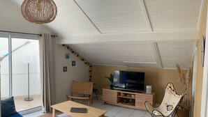Una sala de estar con sofá, mesa de centro, televisor y sillón.