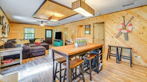 Ein Holzinterieur mit Essbereich, Sofas und einem Fernseher.