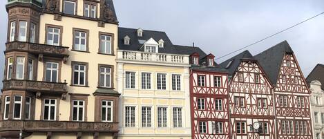 A historic building with a traditional European architectural style, featuring a prominent clock tower and a sign for a hotel.