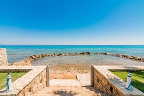 A stone pathway leading to a circular water feature with a clear view of the sea. - Agapi Deluxe Residence, with Pool & Beach Access (Drosia)