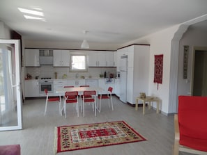 Kitchen features an oven, refrigerator, and central island with a window above the sink.