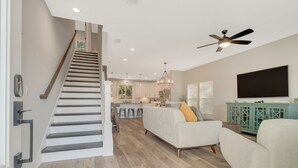 A spacious living area with a staircase, a dining area, and a kitchen. - New Build • Walk to the beach• Bikes • Beach Toys! (St. Augustine)