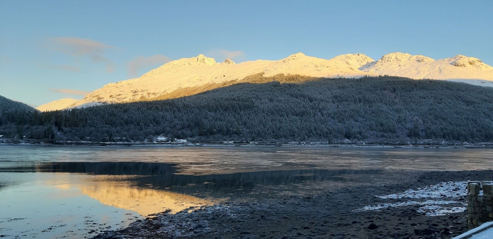 A frozen lake with mountains in the background.