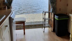 Ein Zimmer mit Blick auf einen See, einer Holzbank, einem Tisch und einem Heizkörper.