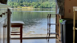 Ein Zimmer mit Blick auf See und Wald, mit Holzmöbeln und einem Papierkorb.