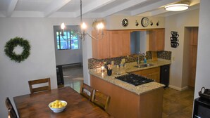 A kitchen with a central island, wooden cabinets, and a dining table with chairs. - Lakeside living awaits at beautiful Lake Milton, OH
 with dock across the street (Lake Milton)