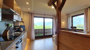 Eine Küche mit Holdekor, einem Herd und einem Fenster mit Blick auf die Berge.