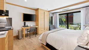 Ein modernes Hotelzimmer mit Bett, Schreibtisch und Fernseher.