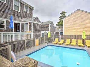 Relax by the pool surrounded by comfortable lounge chairs and a shaded area.