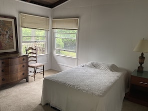 Enjoy a restful stay in this classic room with a neatly made bed, dresser, and window views of the outdoors.