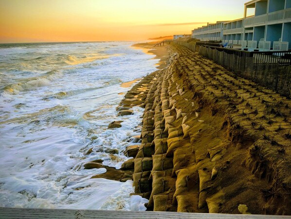 Enjoy the serene beach views from the comfort of your hotel room, overlooking the sandy shoreline and stacked sandbags.