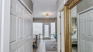 A hallway with white doors, a chandelier, a rug, and a view to a balcony. - WOW Closest to the Gulf Luxury 4 Bed,3Bath 3 Decks Sleeps 14 2500 SF (Pensacola Beach)