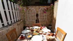 Una mesa puesta para una comida con diversos platos, cubiertos y una cesta de pan.