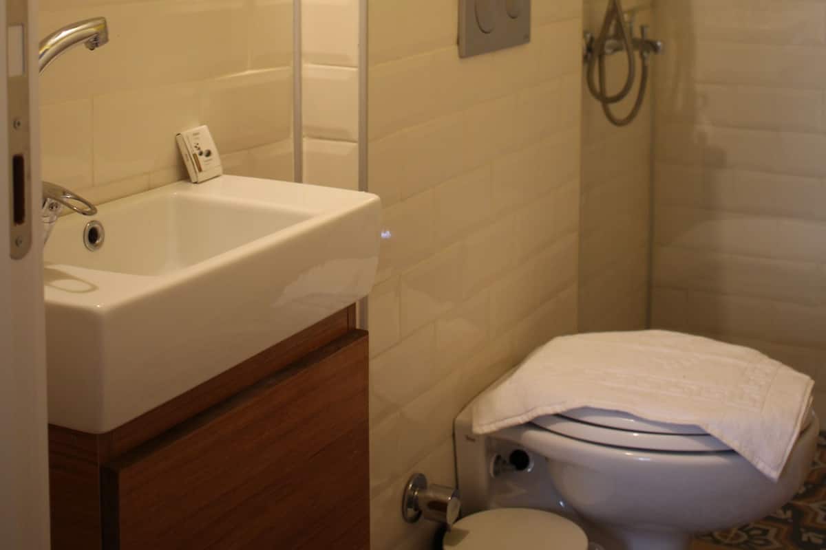 A bathroom with a white sink, toilet, and shower.