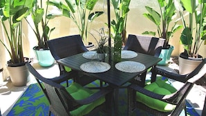 A patio with a table and chairs, surrounded by potted plants. - **Mickeys Hideaway**Walk to Disneyland**Summer Fun! (Anaheim)