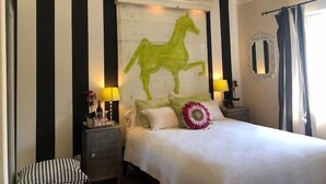 A bedroom with a bed, a nightstand, a lamp, a ceiling fan, and a wall with a horse silhouette. - **Mickeys Hideaway**Walk to Disneyland**Summer Fun! (Anaheim)