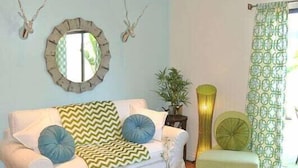 A living room with a white sofa, a round coffee table, and a green armchair. - **Mickeys Hideaway**Walk to Disneyland**Summer Fun! (Anaheim)