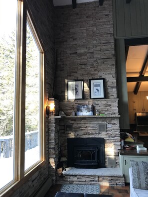 Cozy space with a stone fireplace, framed artwork, and a comfortable seating area.