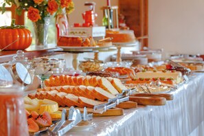 A buffet table with various food items and utensils.