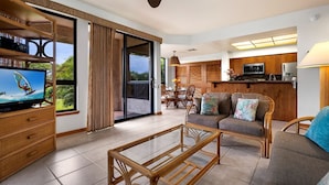 A modern living room with a television, sofa, and dining area.