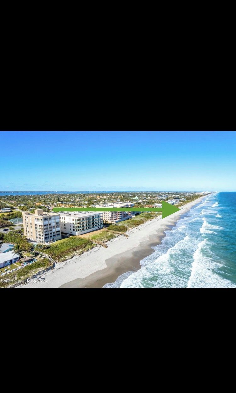 A coastal hotel with multiple buildings, a beach, and ocean views.