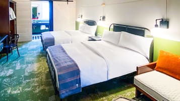 Une chambre d’hôtel avec deux lits, un bureau, une chaise, un ventilateur de plafond et une grande fenêtre.