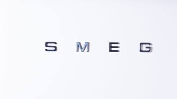 A white surface with the text "SMEG" and two cotton-themed containers.