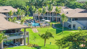 A resort with multiple buildings, a central pool area, and lush greenery.