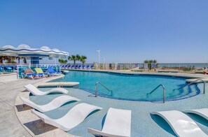 A pool area with lounge chairs, a covered seating area, and a clear view of the beach. - Beautiful Premium Brand New 2 Bedroom Condo w/ Ocean View  (Myrtle Beach)