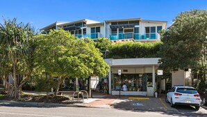 A modern building with a covered entrance, a parking area, and a white car parked in front. - Sempre 7 Sunshine Beach (Sunshine Beach)